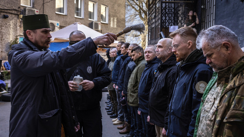 Free Ukraine grubundaki gönüllü askerler artık Kiev Bölgesel Savunma Güçleri'nin bir parçası. Eğitimlerini tamamlamalarının ardından bir rahip tarafından kutsanıyor. 29 Mart 2022 (Fotoğraf: Ivor Prickett/ The New York Times)