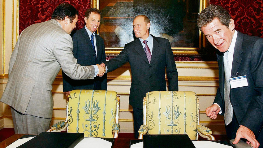 Alfa Group’un CEO’su Mikhail Fridman, Putin ile el sıkışırken dönemin İngiltere Başbakanı Blair ve BP CEO’su John Browne kameralara yansıyor. Burada imzalanan TNK-BP anlaşması İngiliz petrol şirketinin Rusya’da önünü açtı. Yıl: 2003 (Getty Images)