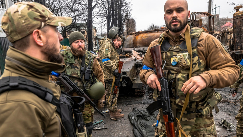 Bir Ukrayna palamiliter grubu olan Azov taburundan askerler, yakın tarihte Rusların çekildiği Buça kasabasının yıkımını gözlemliyor. 2 Nisan 2022. (Daniel Berehulak/The New York Times)