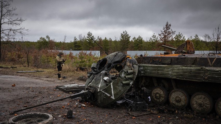 Ukraynalı askerler, Kiev'in batısındaki Dmitrivka'dan çekilen Rus ordusunun yok edilmiş tanklarına ve araçlarına bakıyor. 2 Nisan 2022 (Fotoğraf: İvor Prickett/The New York Times)