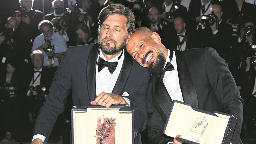 Altın Palmiye alan Triangle of Sadness yapımcıları arasında TRT de var. Robert Östlund ve 75 pırlantalı Altın Palmiye ödülü (solda). En İyi Senaryo Ödülü kazanan Tarık Saleh (sağda)