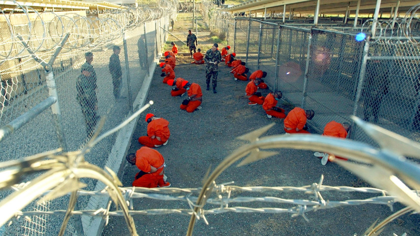 Guantanamo Körfezi Deniz Üssü'ne getirilen ilk 20 tutuklu, 11 Ocak 2002'de varışlarından kısa bir süre sonra dikenli tellerle çevrili bir alanda tutulurken görülüyor (Fotoğraf: Petty Officer 1st class Shane T. McCoy/U.S. Navy via NYT)