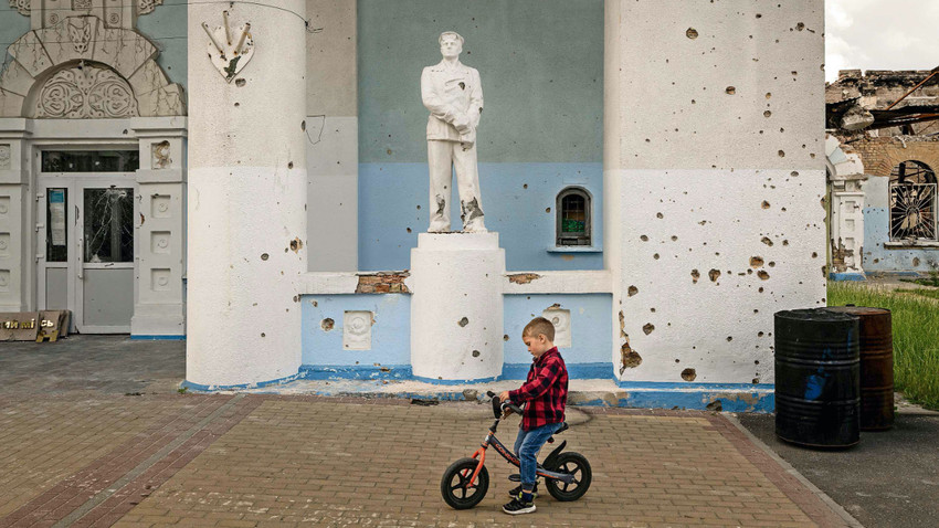 Ukrayna’nın Iprin kentinde ağır hasar gören Şampiyonlar Stadyumu önünden bir çocuk  15 Haziran günü bisikletiyle geçiyor (Fotoğraf: Nicole Tung/The New York Times)