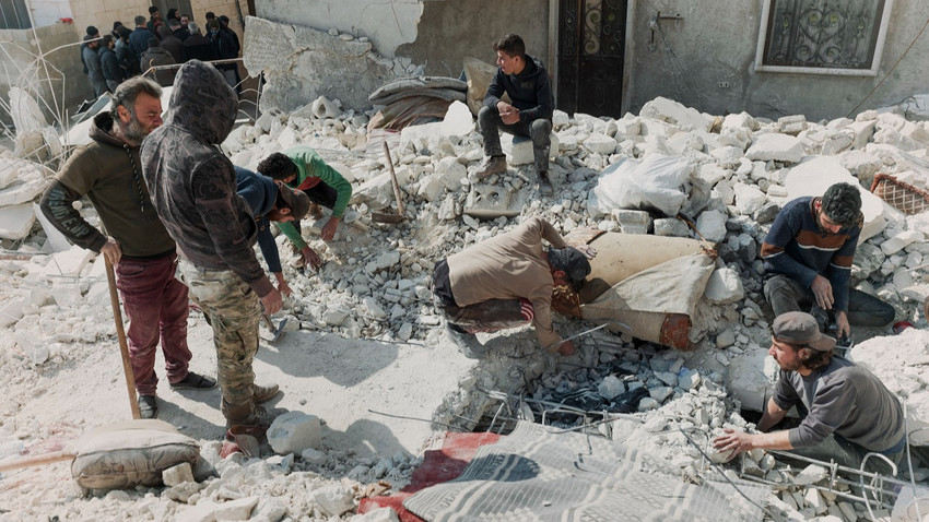 İnsanlar, Suriye'nin Halep vilayetindeki Atarib'de yıkılan evlerinin molozlarını karıştırıyor, 12 Şubat 2023 (Emily Garthwaite/New York Times)