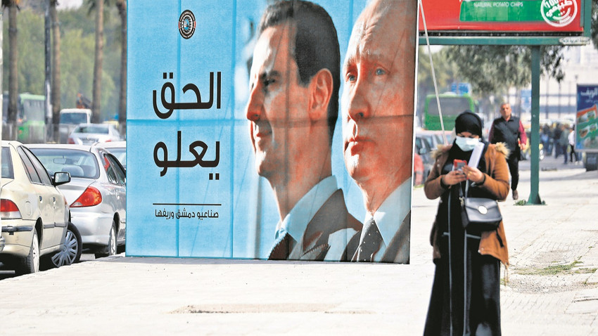 Şam’ın merkezindeki bu pankartta Esad ve Putin fotoğraflarının yanında “Adalet yerini bulur” yazıyor. (Fotoğraf: Louai Beshara /AFP via Getty Images)