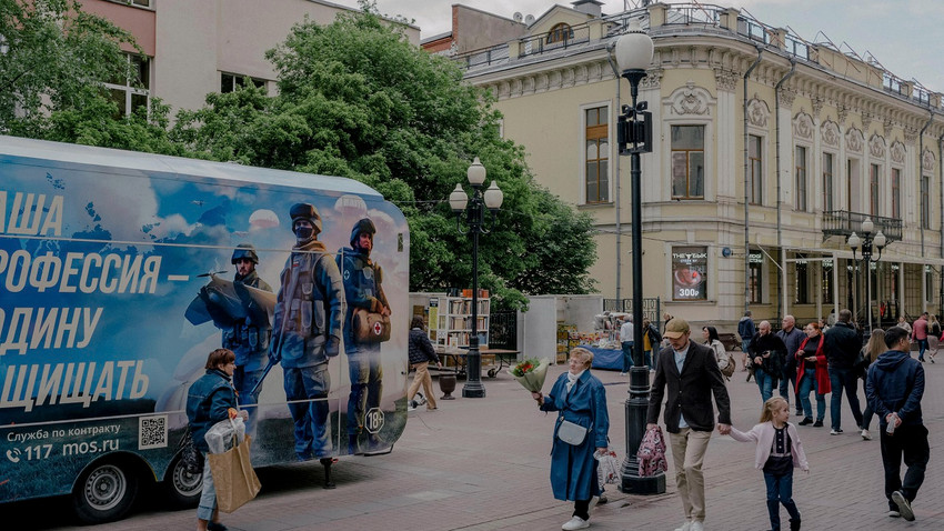 Yayalar 20 Mayıs 2023'te Moskova'nın merkezinde seyyar bir asker alma otobüsünün önünden geçiyor (Fotoğraf: Nanna Heitmann/The New York Times)