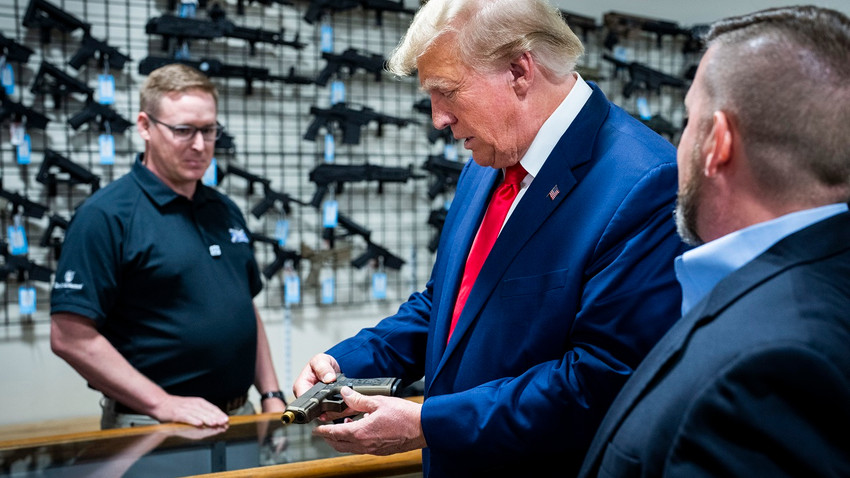 Donald Trump, 25 Eylül'de Palmetto State Armory'yi ziyareti sırasında kendi adı ve kabartmasıyla süslenmiş bir Glock tabancayı inceledi (Fotoğraf: Doug Mills/The New York Times)