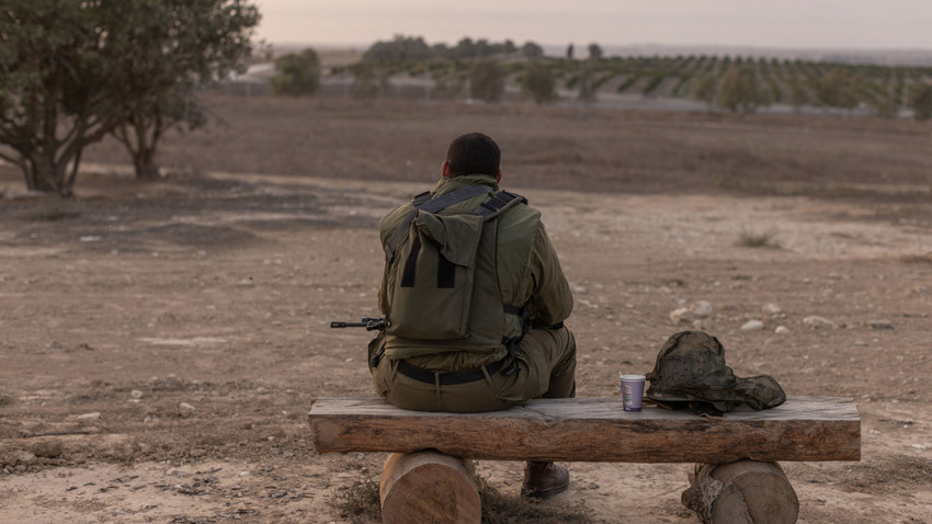 8 Ekim'de İsrail'de kucağında tüfeğiyle oturan bir asker (Fotoğraf: Avishag Shaar-Yashuv/The New York Times)