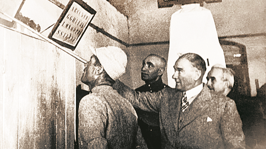 23 Haziran 1934. Atatürk İzmir Garnizon’unda bir erin okumasını sınarken İnönü ve Şah Rıza onları izliyor.