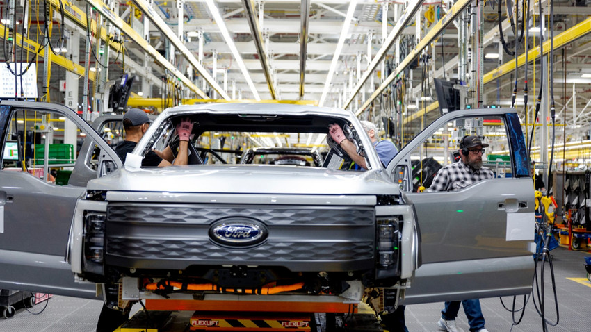 Ford çalışanları 4 Nisan 2022'de Ford'un Mich'deki genel merkezinde montaj hattında gümüş renkli bir F-150 Lightning kamyon üzerinde çalışıyor. (Fotoğraf: Sylvia Jarrus/The New York Times)