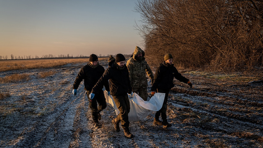 Bir insani yardım grubunun üyeleri, Ukrayna'nın Donetsk bölgesinde bir Rus askerinin cesedini taşıyor, 7 Ocak 2023 (Fotoğraf: Nicole Tung/The New York Times)