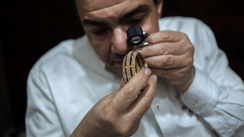Kahire'de, şehrin altın dükkanlarının çoğuna ev sahipliği yapan Han el-Halili pazar alanındaki bir dükkanda bir tüccar bir bileziği inceliyor, 1 Mart 2024. (Fotoğraf: Fatma Fahmy/The New York Times)
