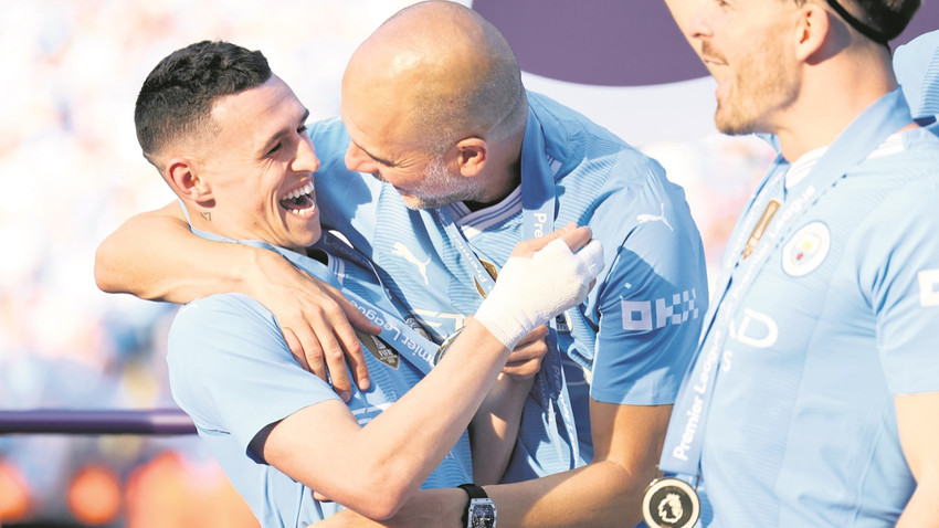 City oyuncuları Phil Foden (solda) ve Jack Grealish, hocaları Pep Guardiola ile şampiyonluğu kutluyor.