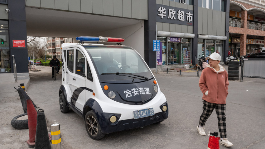 Pekin'in banliyölerinden Zhangjiawan'da bir apartman kompleksinin girişinde bir polis aracı, 3 Nisan 2024 (Fotoğraf:Gilles Sabrié/The New York Times)