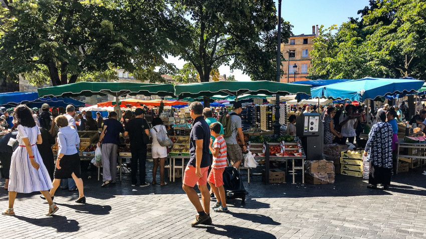 Bordeaux'daki ünlü Basicila ve kulesi yakınındaki Saint-Michel pazarında alışveriş yapan turistler