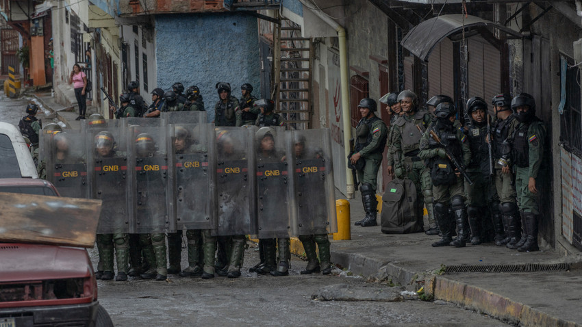 Ulusal Muhafız askerleri seçimden bir gün sonra Venezuela'nın Caracas kentinde düzenlenen bir protestoya müdahale ediyor-Alejandro Cegarra for The New York Times