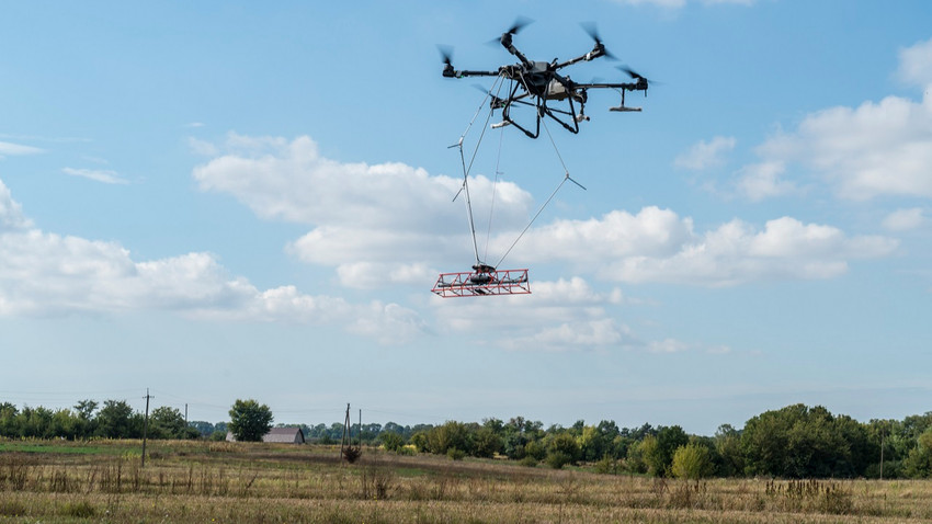 Bir tarım dronu, Ukrayna'nın Zhytomyr bölgesinde kara mayınlarını tespit etmeye yardımcı olacak bir manyetik sensör taşıyor, 20 Eylül 2023 (Fotoğraf: Brendan Hoffman/The New York Times)