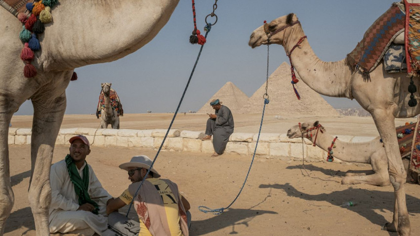 Giza, Mısır'da turistleri gezdiren develer, 19 Eylül 2023. (Mauricio Lima/The New York Times)