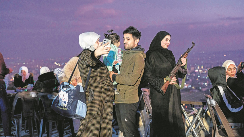 Halk Kasiyun Dağı’na akın etmiş, oturacak yer bulmak zor. Aileler çay-nargile keyfi yapıyor, arada HTŞ milislerinin silahlarıyla hatıra fotoğrafları çekiyorlar