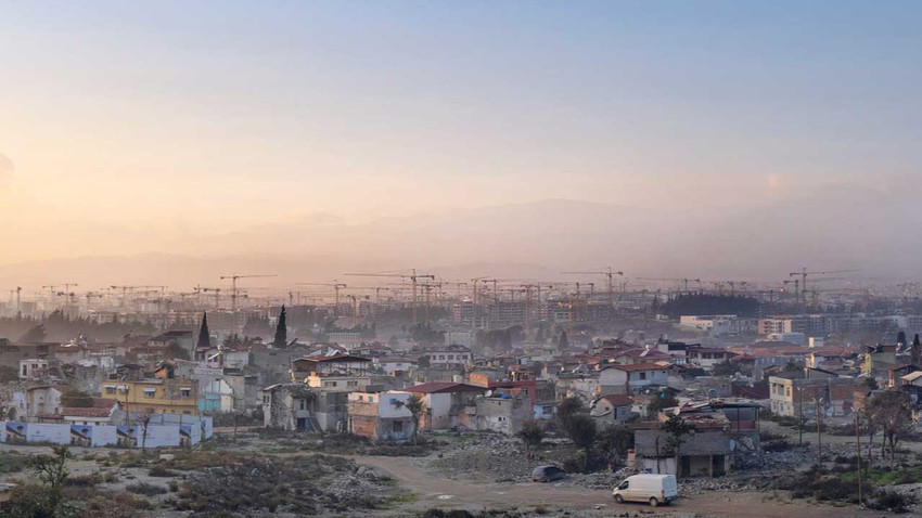 Habibi Neccar Dağı’nın eteklerinden bakıldığında ön tarafta eski Antakya, sonra Asi Nehri, onun ardında da konut ve işyerinin yapımı için kurulan şantiyelerde yükselen binlerce vinç görünüyor. (Fotoğraf: Kazım Kızıl)