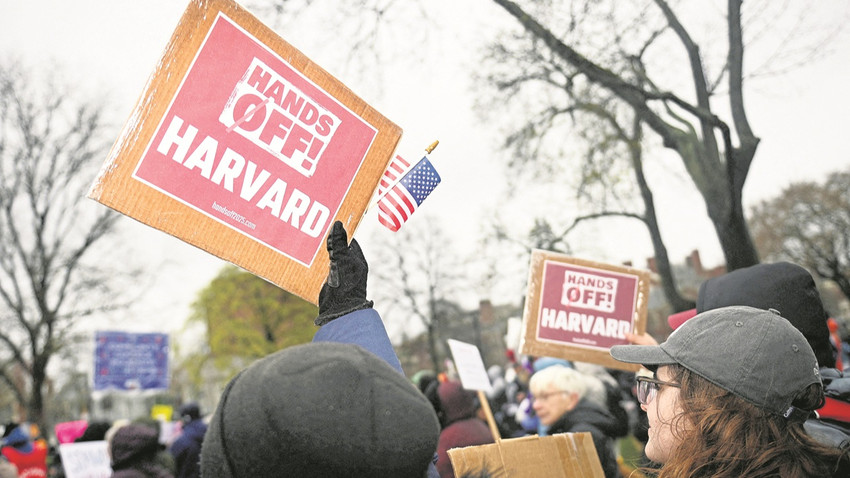 Harvard’lı öğrenciler ve onlara destek veren vatandaşlar, Trump yönetiminin federal yardımları kesme tehdidini, “Harvard’dan elinizi çekin” pankartlarıyla protesto etti. (Fotoğraf: Reuters)