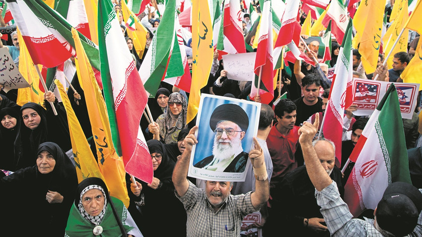 Tahran'da bazı İranlılar ateşkesi dini lider Hamaney'in posterleriyle kutladı. (Fotoğraf: Getty Images)