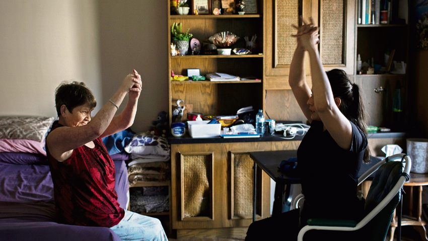 Terapist Azul Gordiano (sağda) Debra McVean’e Calgary Alberta’daki evinde rehabilitasyon için yardımcı oluyor. Vean, birkaç ay sonra Maraviroc adlı felç ilacını denemeye başladı. (Fotoğraf: Amber Bracken/The New York Times)