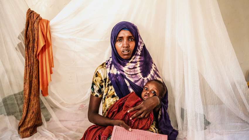 Somalili bir anne, Baidoa'daki bir sağlık merkezinde sadece 5.4 kilogram ağırlığında olan 8 aylık bebeğini tutuyor. (Fotoğraf: Brian OtIeno /The New York Times)